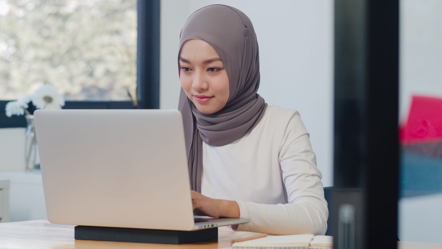 Young girl working on laptop at home